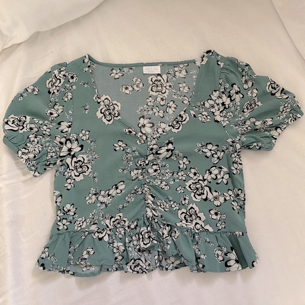 Cropped blouse with puff sleeves and ruffle at bottom.  Also scrunches in front
